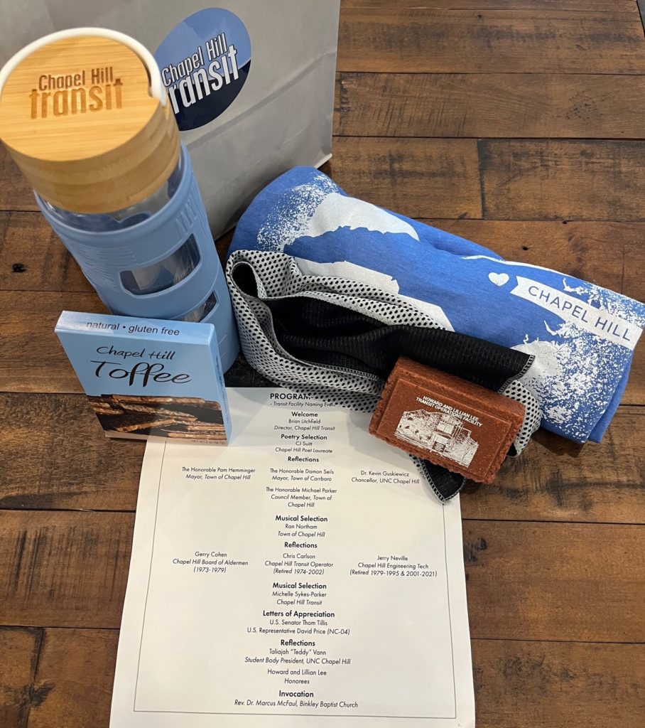 An image showing a water bottle, a rolled up tshirt, a paper weight, and a candy bar, with an event agenda.