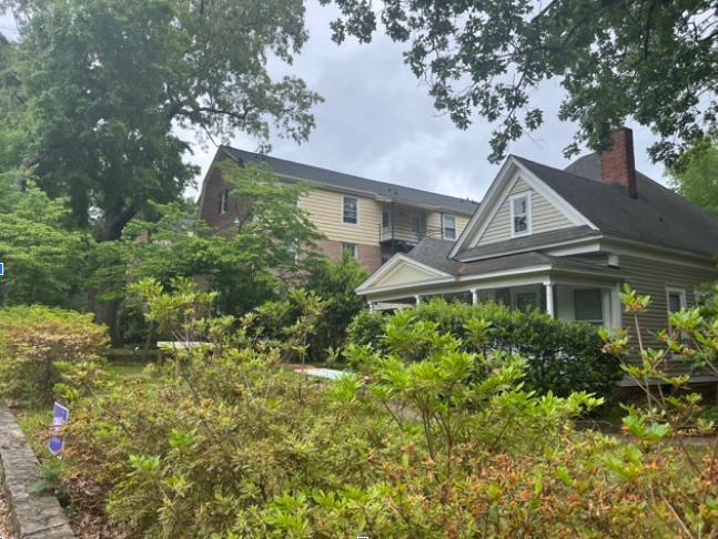 Look, a two-story house next to a four-story apartment building in a historic district (235 McCauley St).