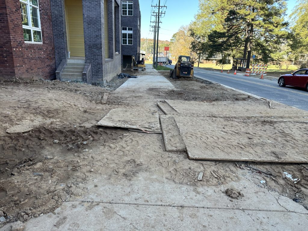 Photograph of an obstructed sidewalk adjacent to an active construction site.