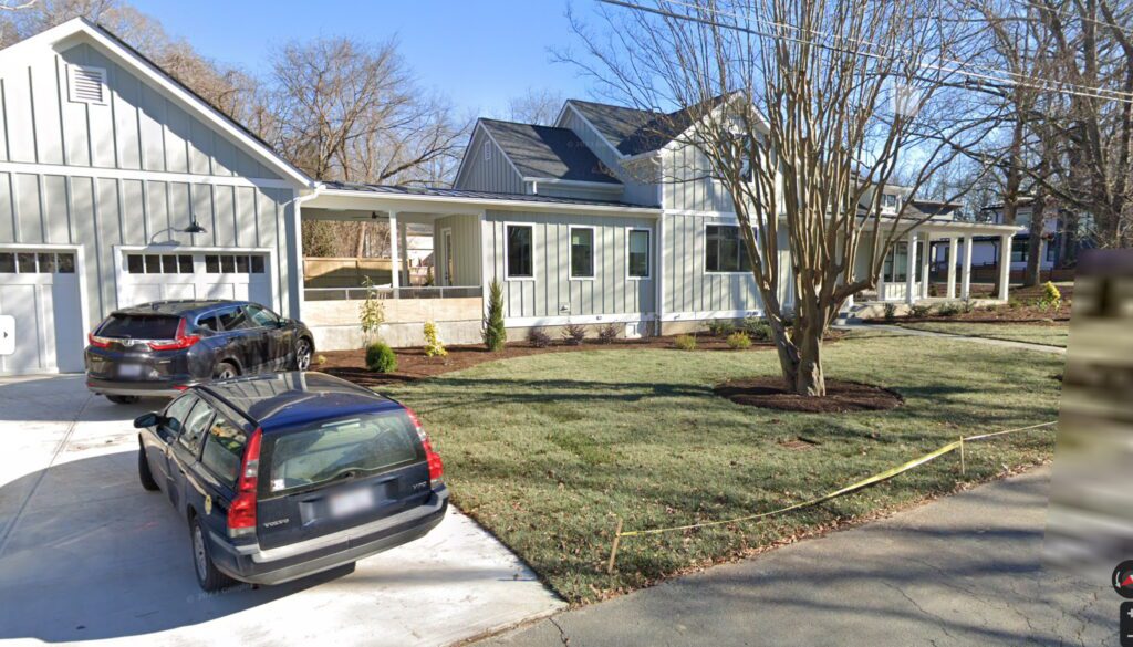 Photo of a long house with a large lawn