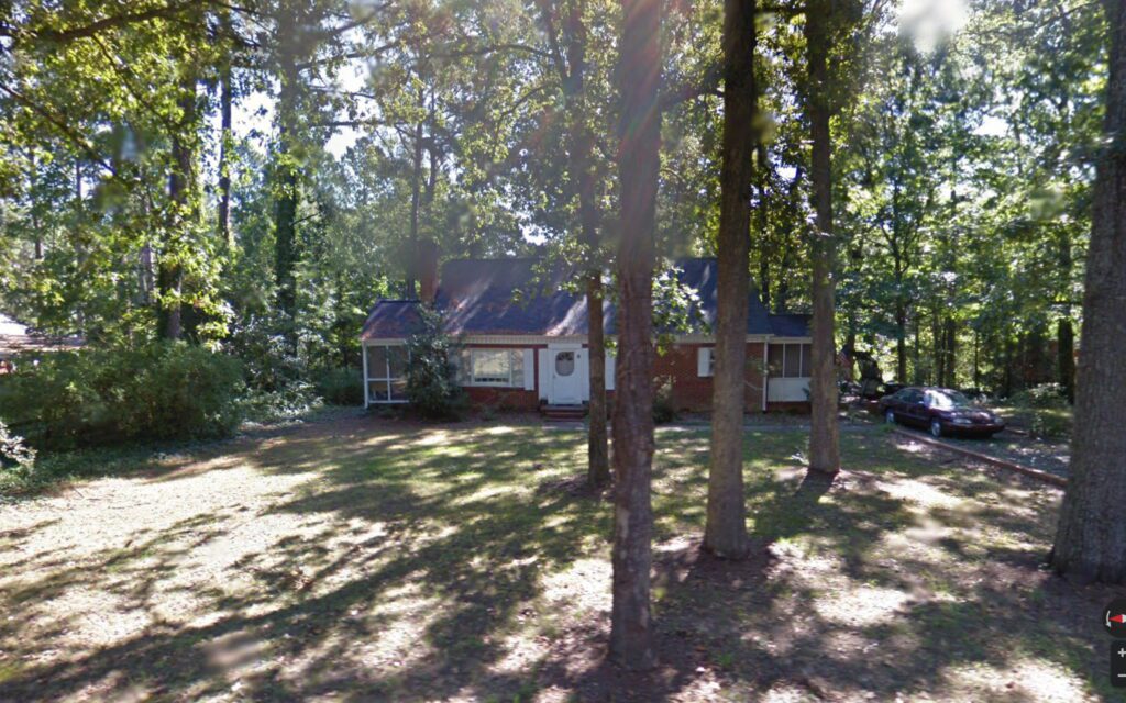 Photo of a small house on a wooded lot
