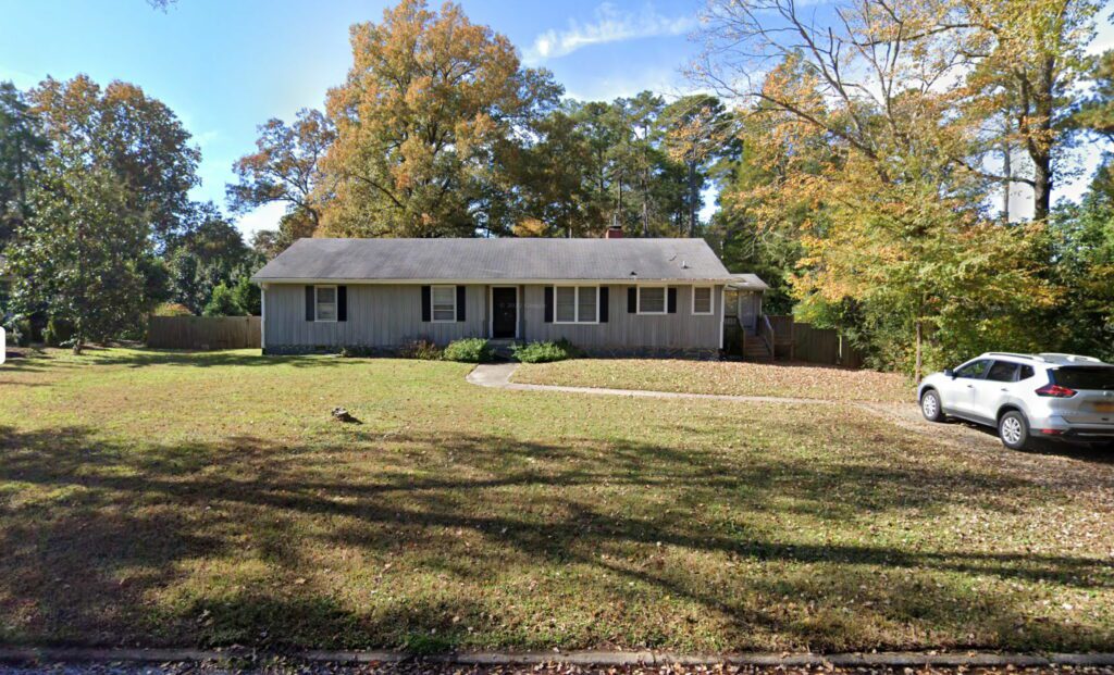 Photo of a small house on a grass lot.