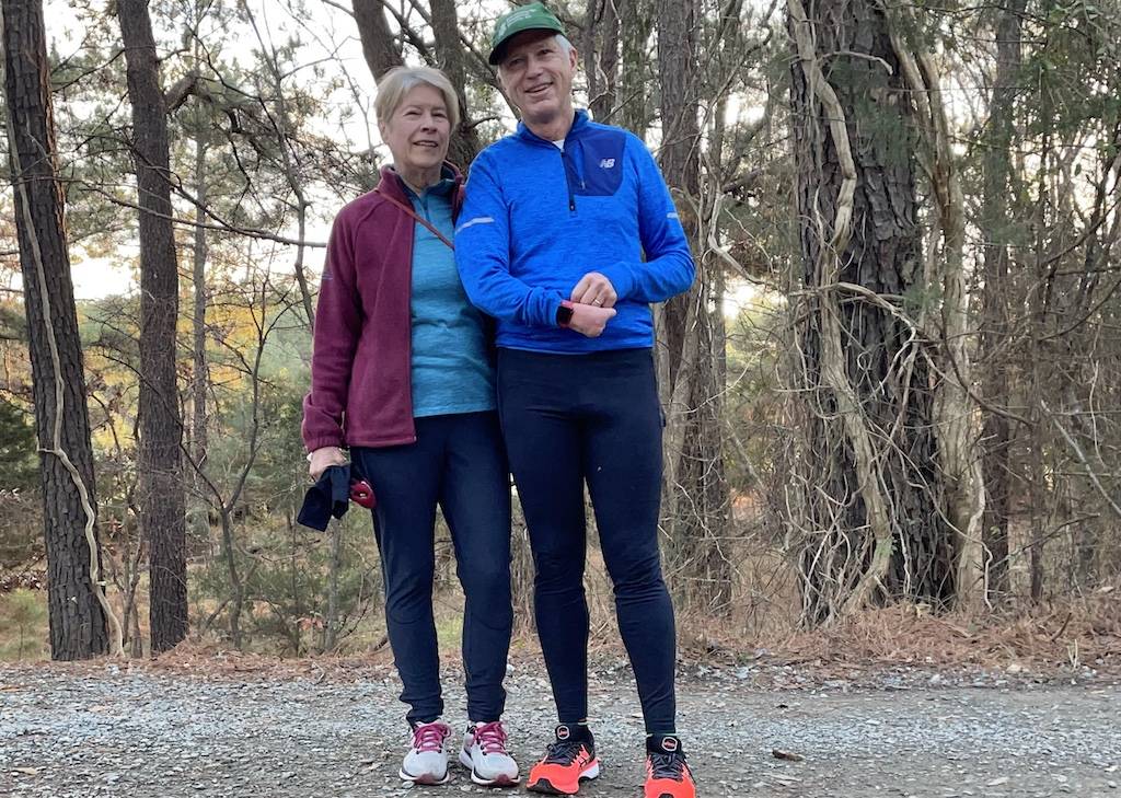 Two runners posing for a photo in the forest on the pumpkin loop