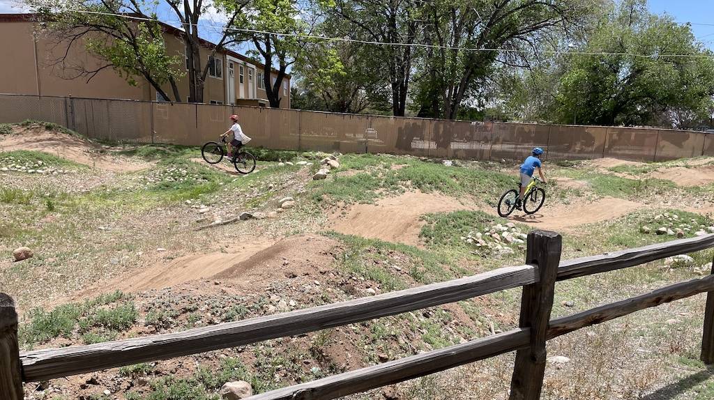 Children enjoy a ride on an adjacent pump track 