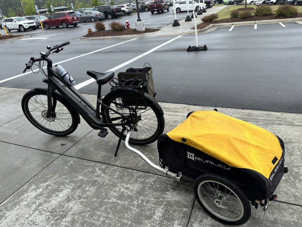 Photograph of an electric bike with a trailer behind it.