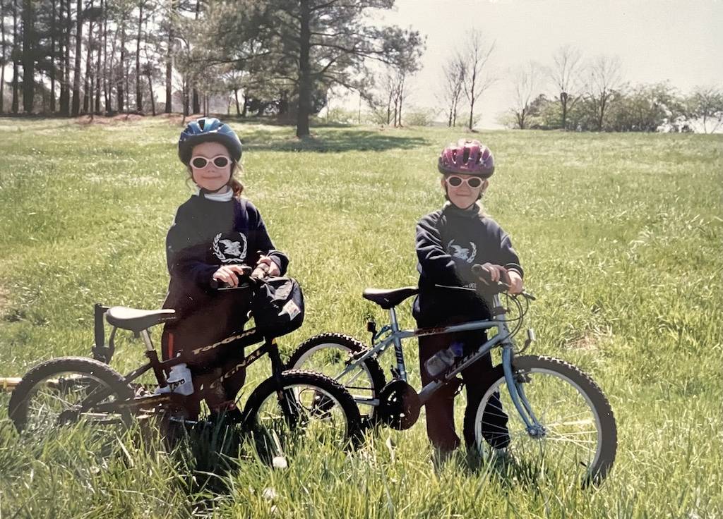 Two children standing next to bikes in RTP