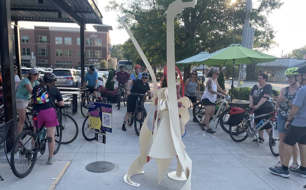 Cyclists looking at art from the Uproar Festival of Public Art