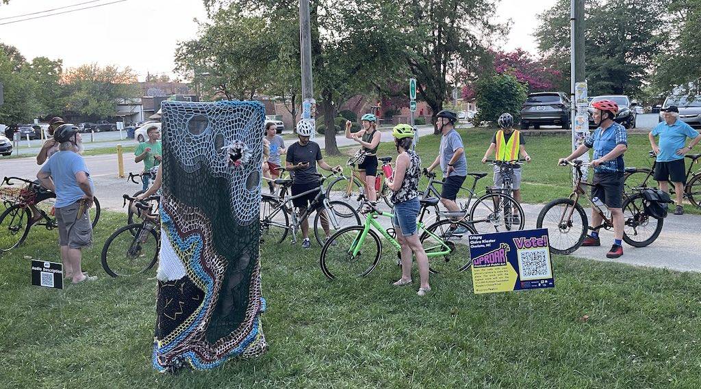 Cyclists looking at art from the Uproar Festival of Public Art