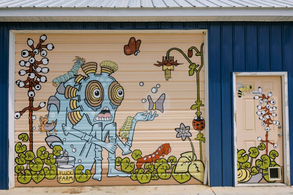 Mural on garage door at Steel String Brewery at Pluck Farm
