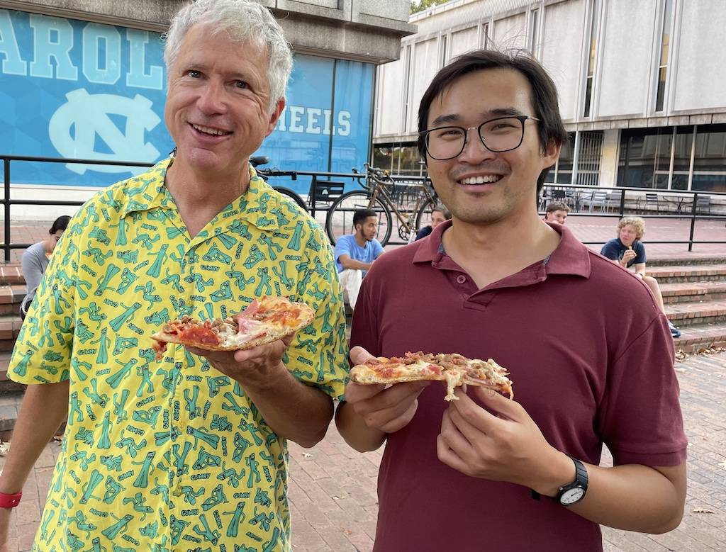 Two people eating pizza at the Pit on UNC campus