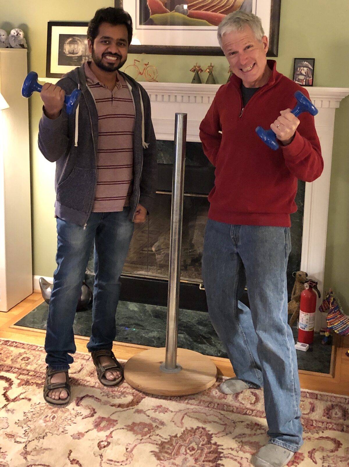 Two people practicing feats of strength next to a Festivus pole