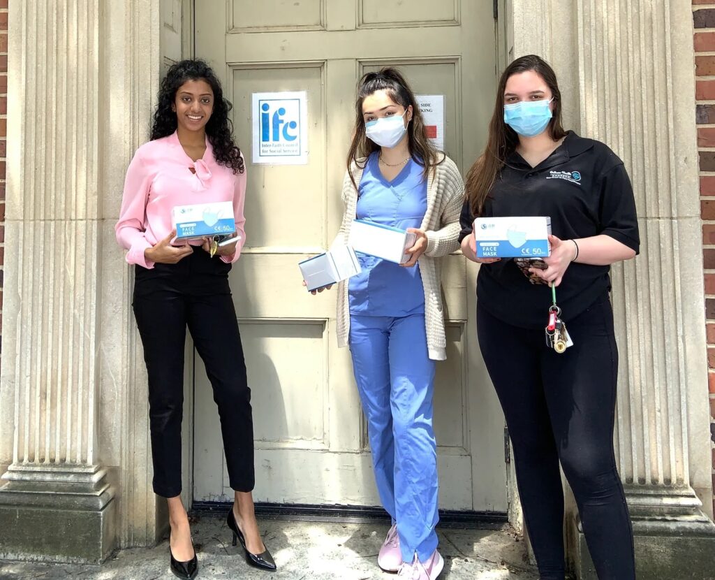 Railcare volunteers holding boxes of facemask outside the old IFC location
