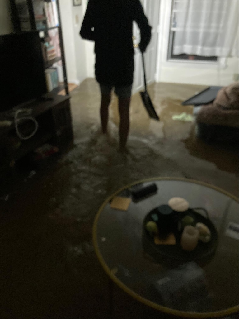An affected resident working to rescue items from a Canterbury living room
