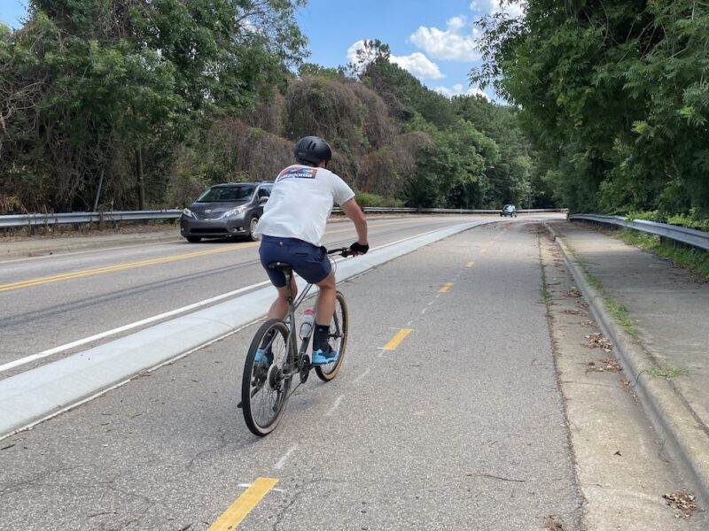 A curb separated bike lane with a cyclists riding on it