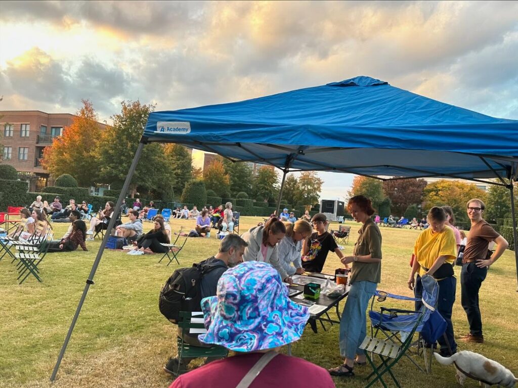 Activity at the auction tent at sunset on the green