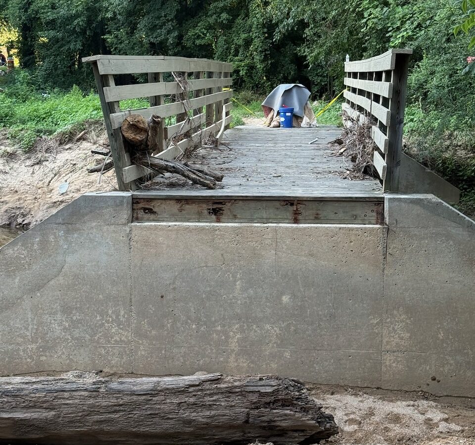Photo of damage along the Fordham Boulevard greenway in Chapel Hill, showing the approach to a bridge over Bolin Creek with the approach missing