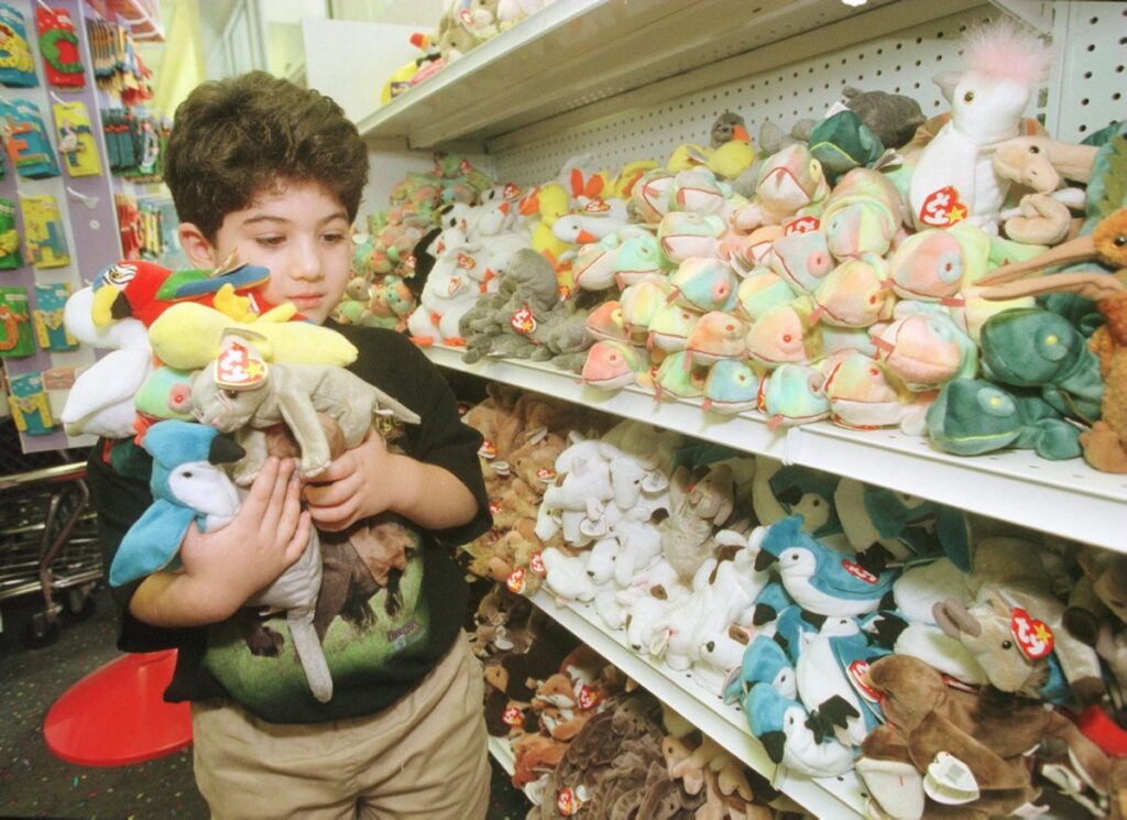 A child holds an armful of beanie babies in a toy store