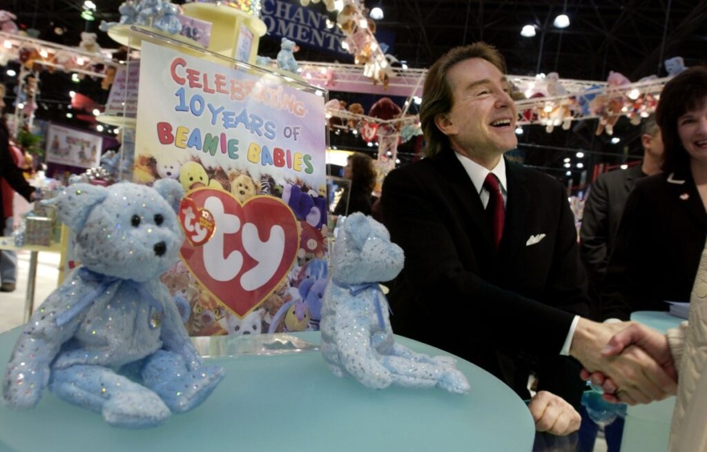 A Business man shakes hands at a beanie e baby booth at a trade show