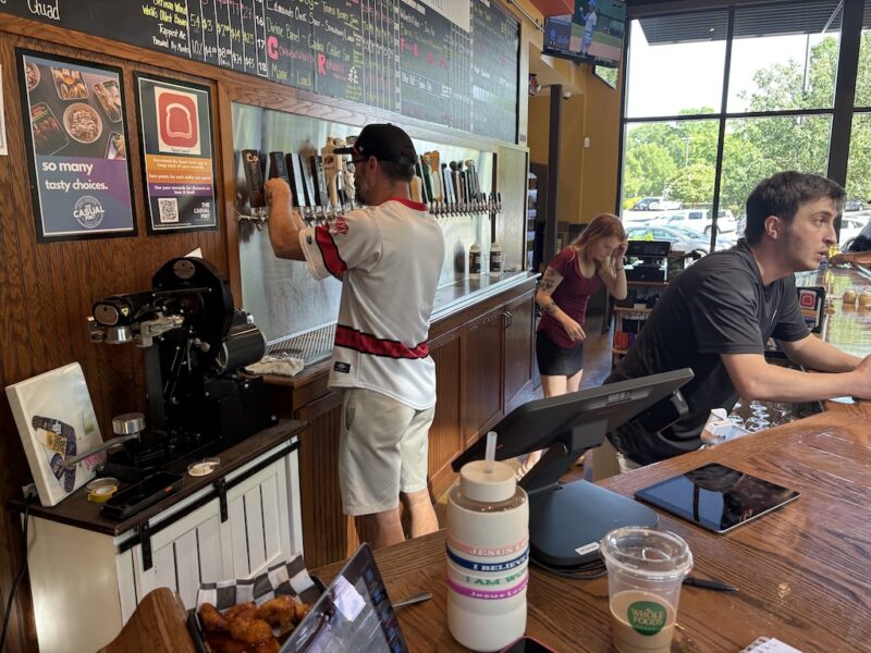 A man pours a beer at a tap