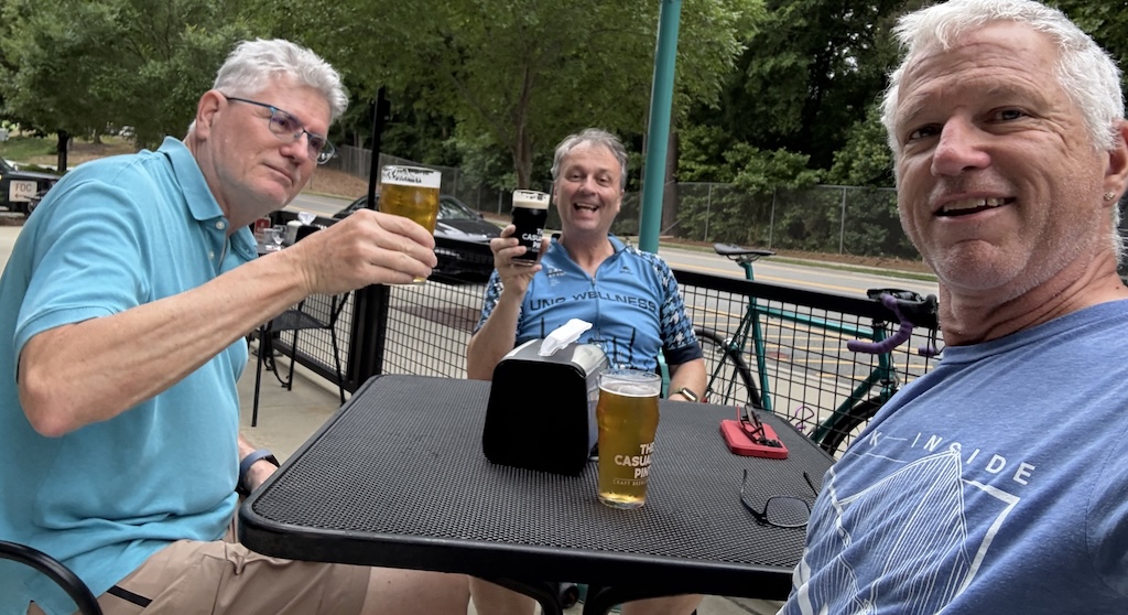 # men enjoy pints at an outdoor table